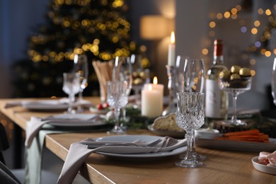 Photo of Christmas table setting with festive decor and dishware indoors