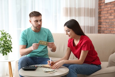 Beautiful young couple with money at home