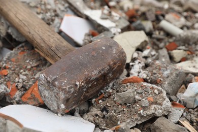 Photo of Sledgehammer on pile of broken bricks, closeup