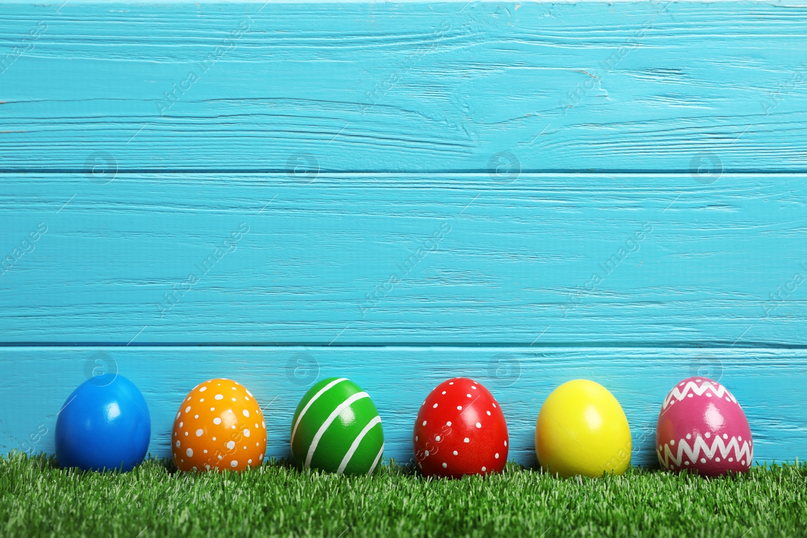 Photo of Decorated Easter eggs on green grass. Space for text