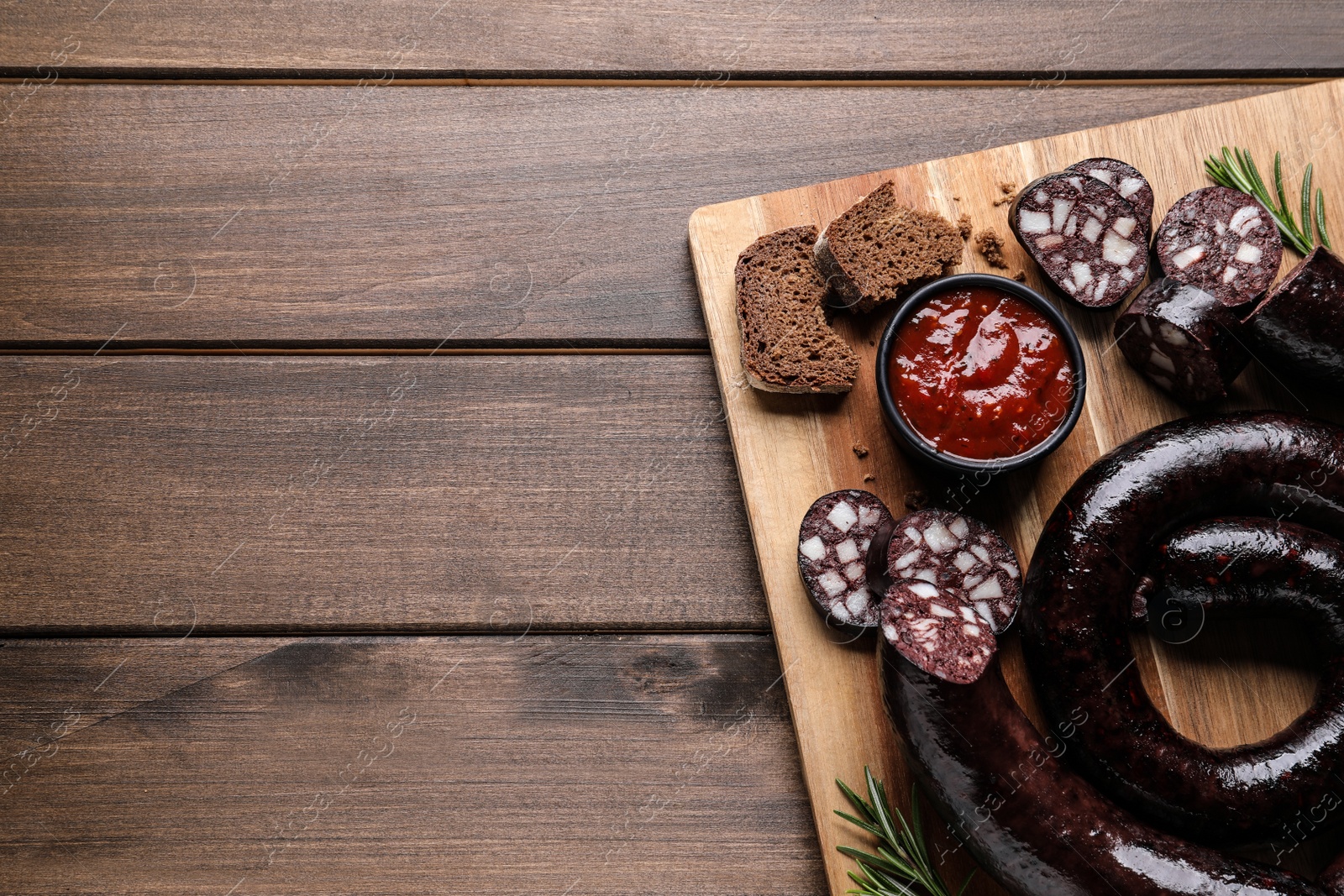 Photo of Tasty blood sausages served on wooden table, top view. Space for text