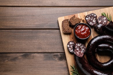 Tasty blood sausages served on wooden table, top view. Space for text