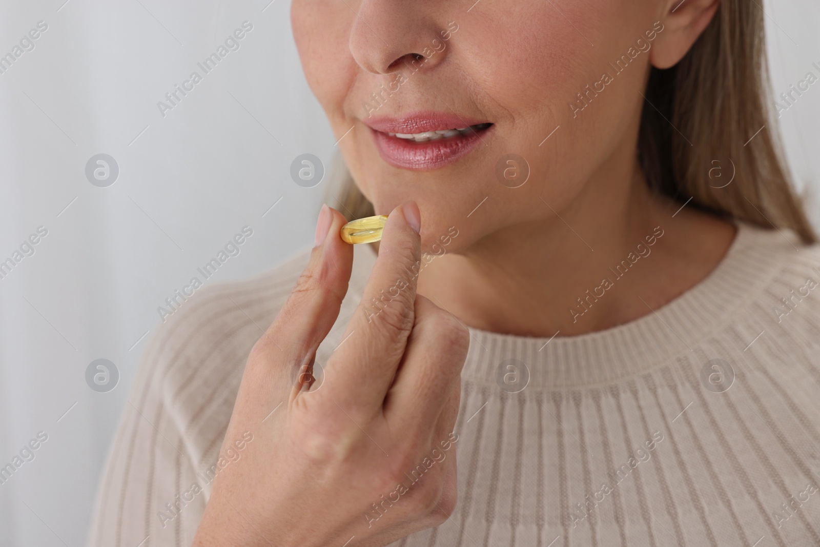 Photo of Woman taking vitamin pill at home, closeup