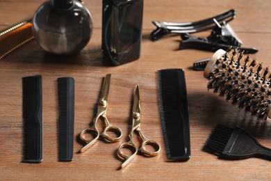 Photo of Hairdresser tools. Different scissors and combs on wooden table
