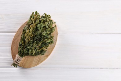 Bunch of dry parsley on white wooden table, top view. Space for text