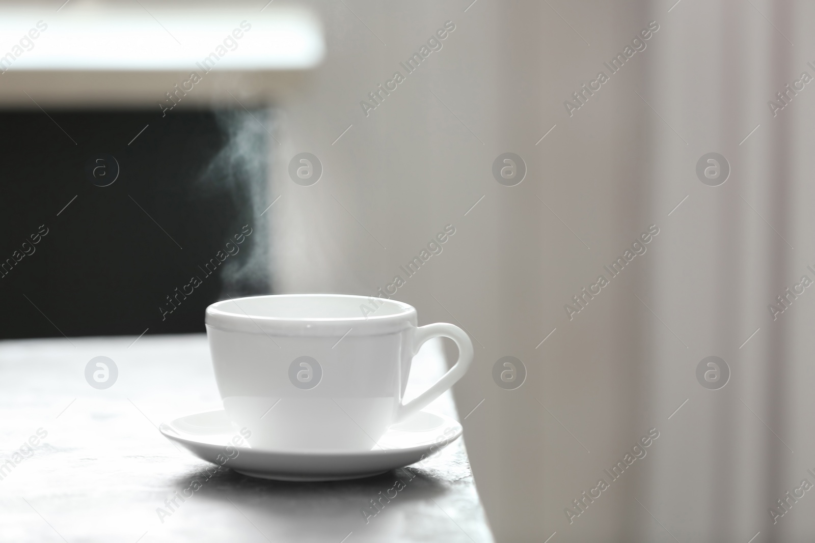 Photo of Cup of tea and saucer on table indoors