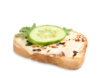 Slice of bread with spread, cucumber and arugula on white background