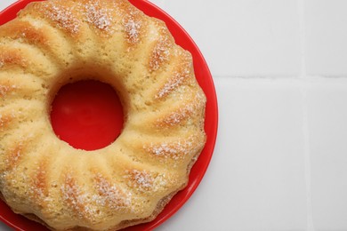 Photo of Delicious freshly baked sponge cake on white tiled table, top view. Space for text