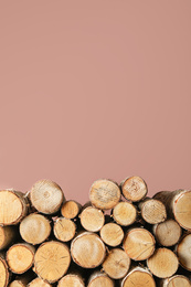 Photo of Cut firewood on pink background. Space for text
