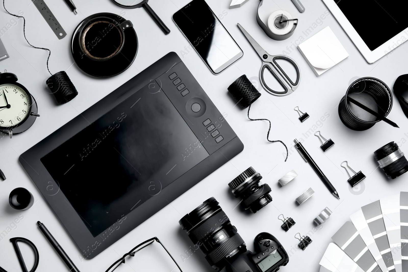 Photo of Flat lay composition with graphic drawing tablet and different office items on light background. Designer's workplace