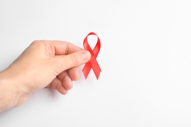 Photo of Woman holding red ribbon on white background. Cancer awareness