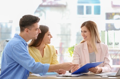 Photo of Young couple meeting with consultant in office