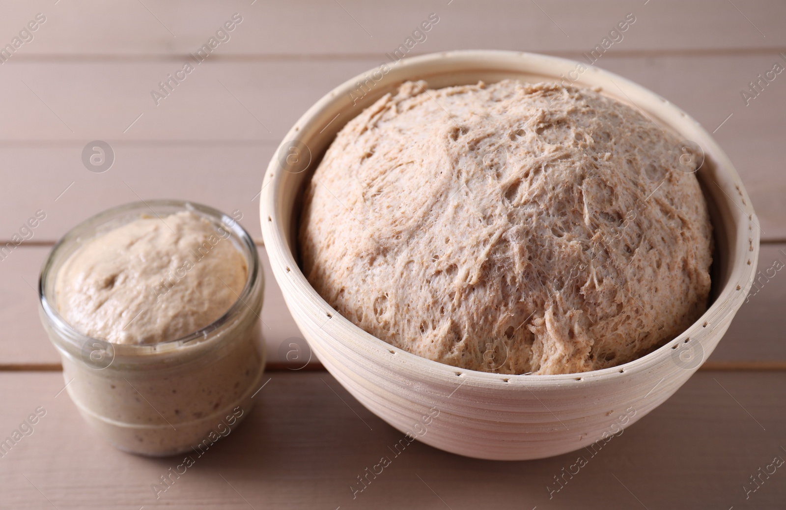 Photo of Fresh sourdough starter and dough on wooden table