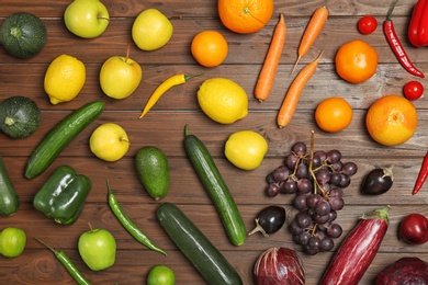 Photo of Rainbow composition with fresh vegetables and fruits on wooden background, flat lay