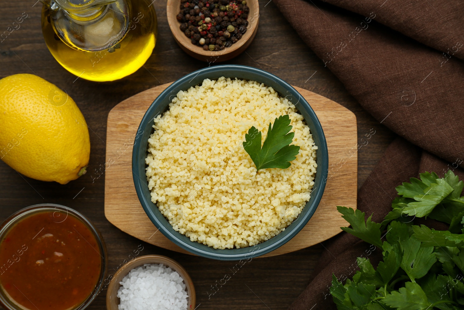 Photo of Tasty couscous and ingredients on wooden table, flat lay