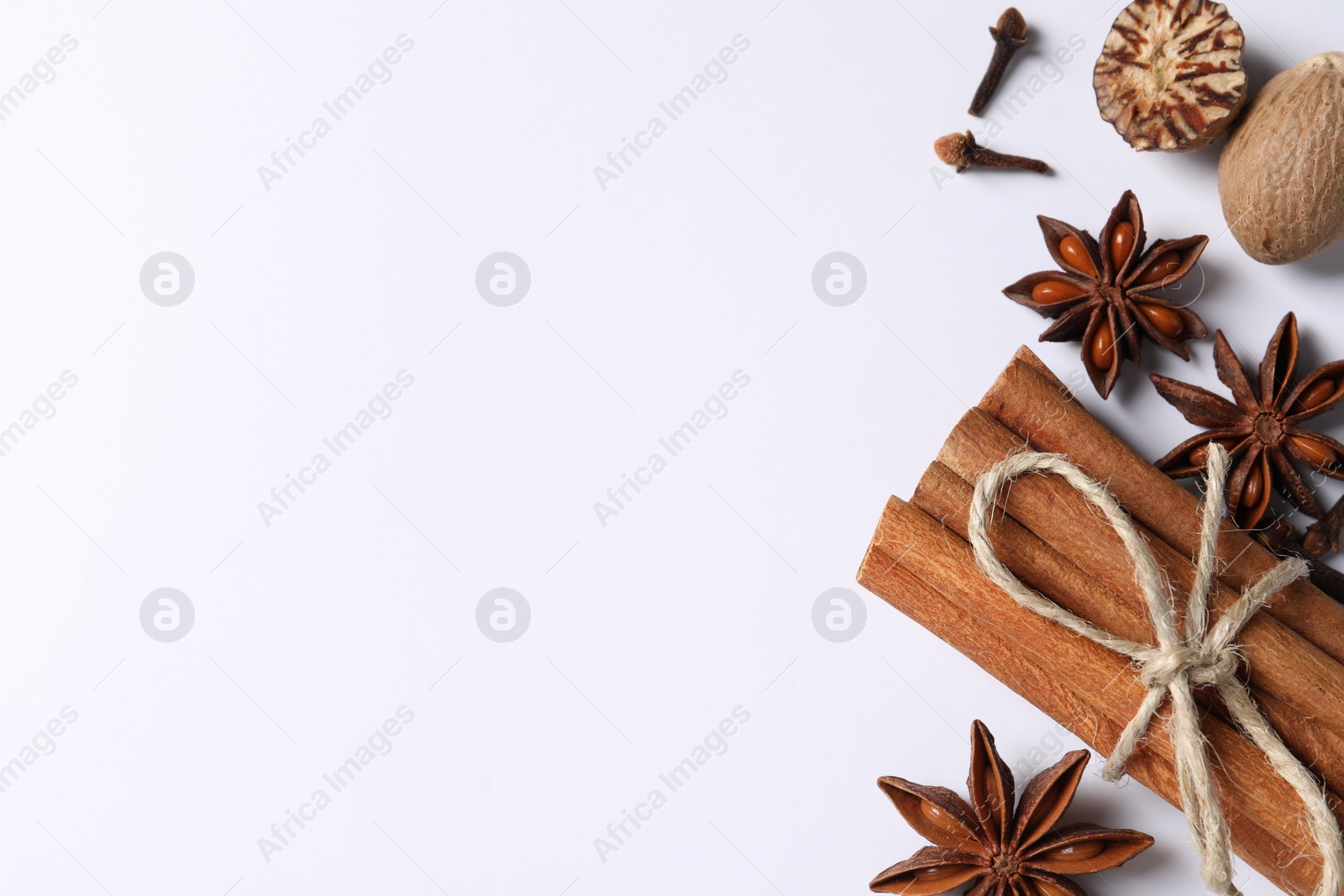 Photo of Different spices and nuts on white background, flat lay. Space for text