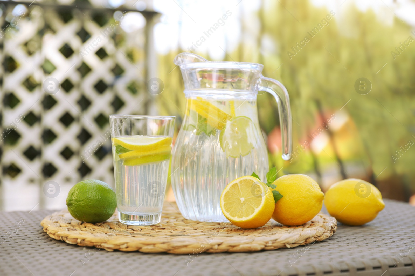 Photo of Water with lemons and limes on table outdoors