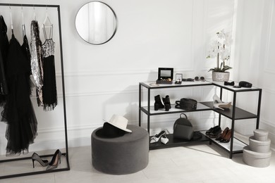 Stylish dressing room interior with trendy clothes, shoes and accessories