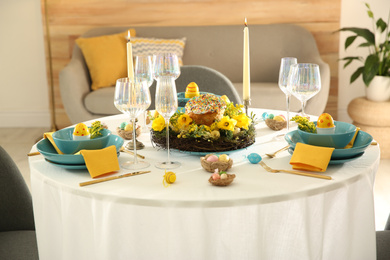 Festive Easter table setting with beautiful floral decor and eggs indoors