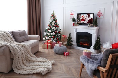 Image of Stylish living room interior with TV set, Christmas tree and fireplace