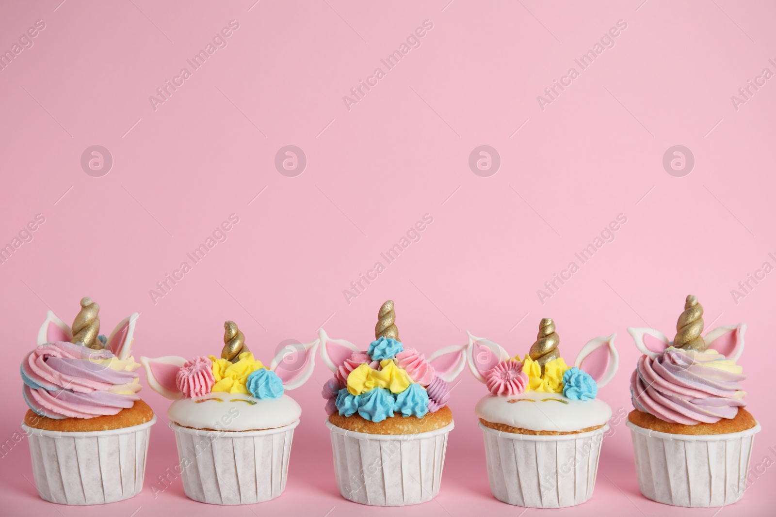 Photo of Many cute sweet unicorn cupcakes on pink  background