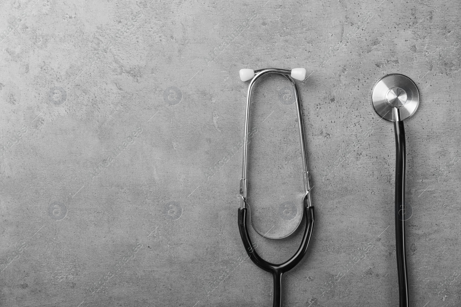 Photo of Stethoscope for checking pulse and space for text on gray background, top view