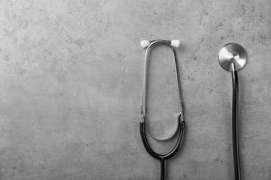 Photo of Stethoscope for checking pulse and space for text on gray background, top view