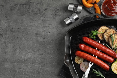Delicious grilled sausages and vegetables on grey table, flat lay. Space for text
