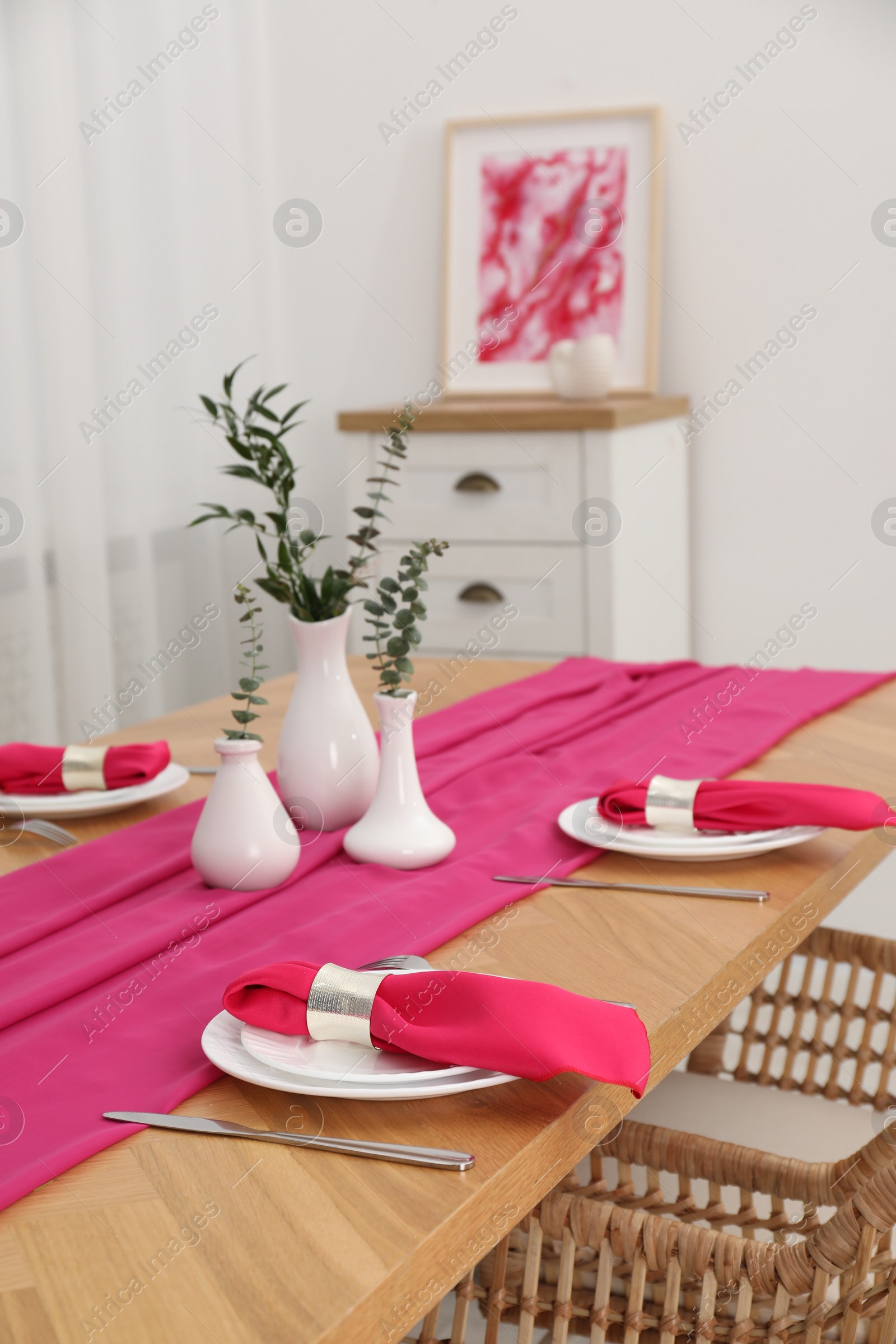 Photo of Beautiful table setting and vases with green branches in dining room