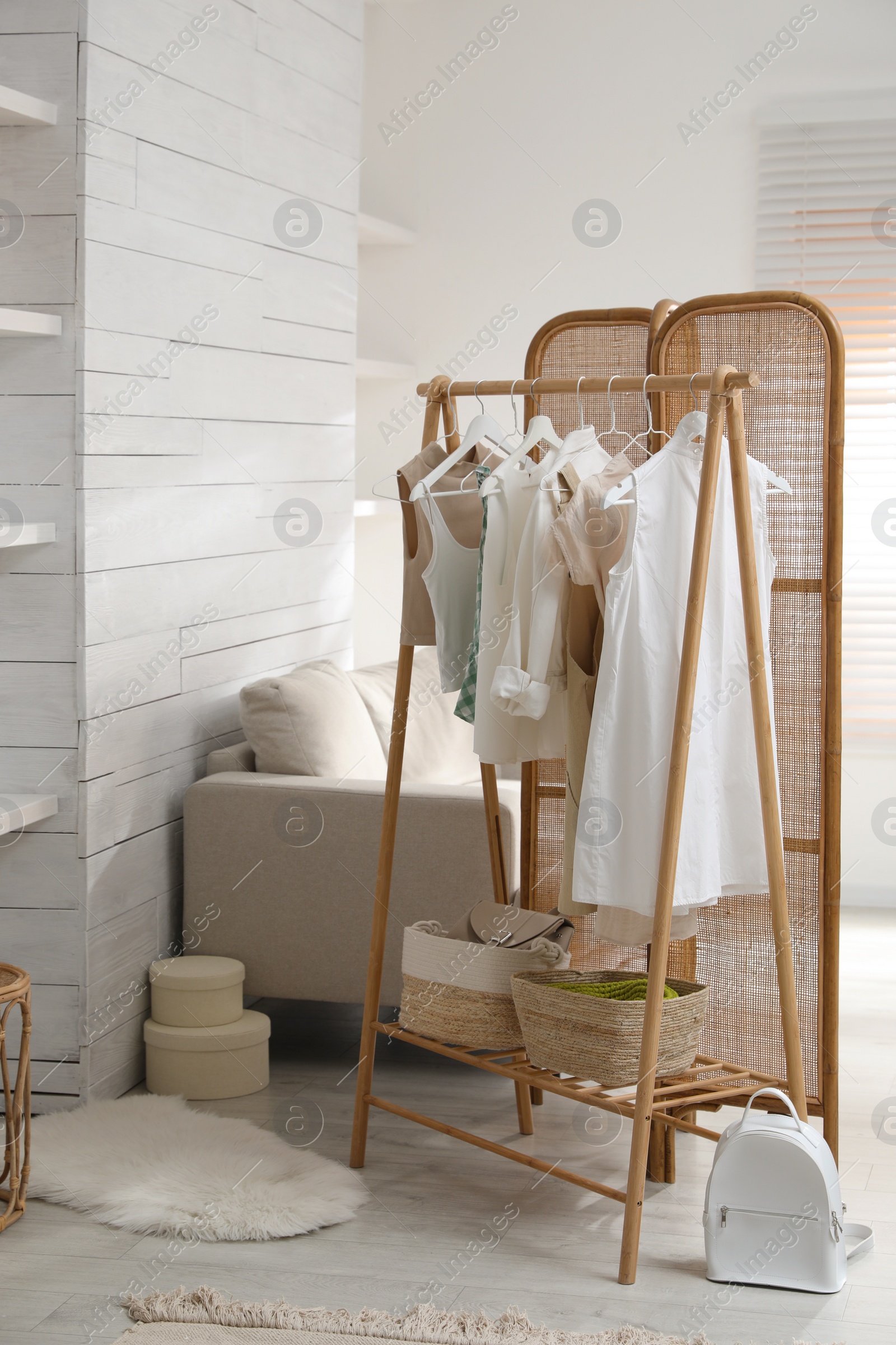 Photo of Rack with stylish women's clothes in dressing room