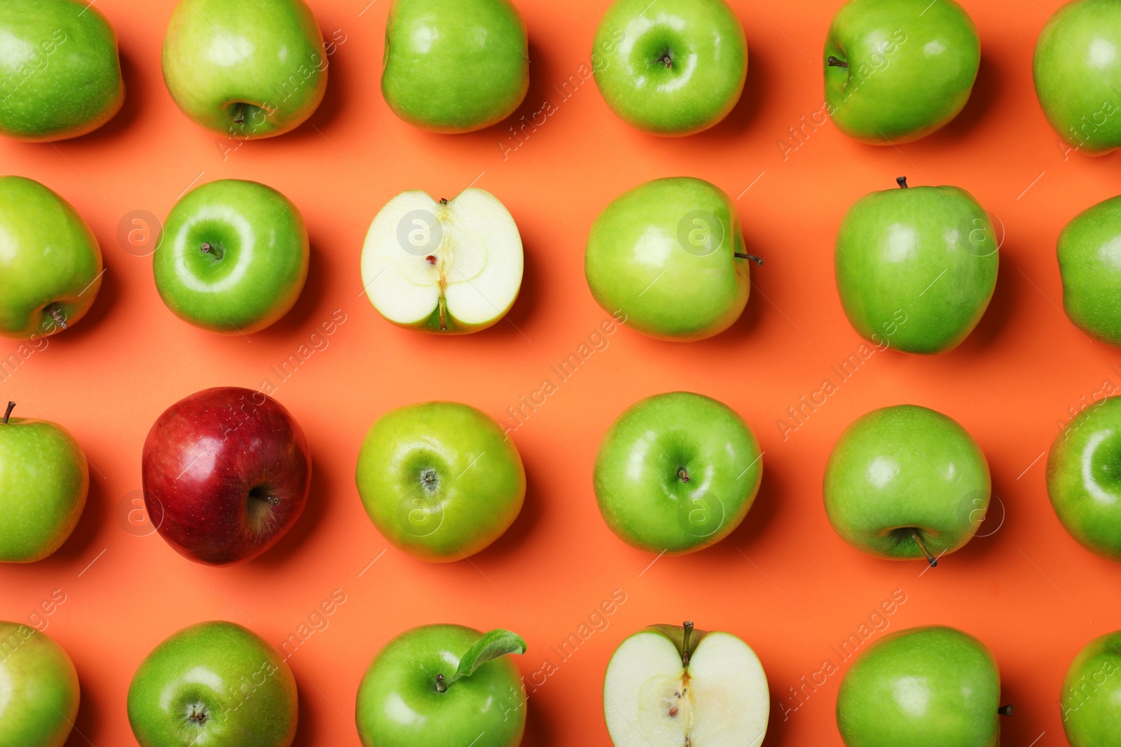 Photo of Tasty green apples and red one on orange background, flat lay