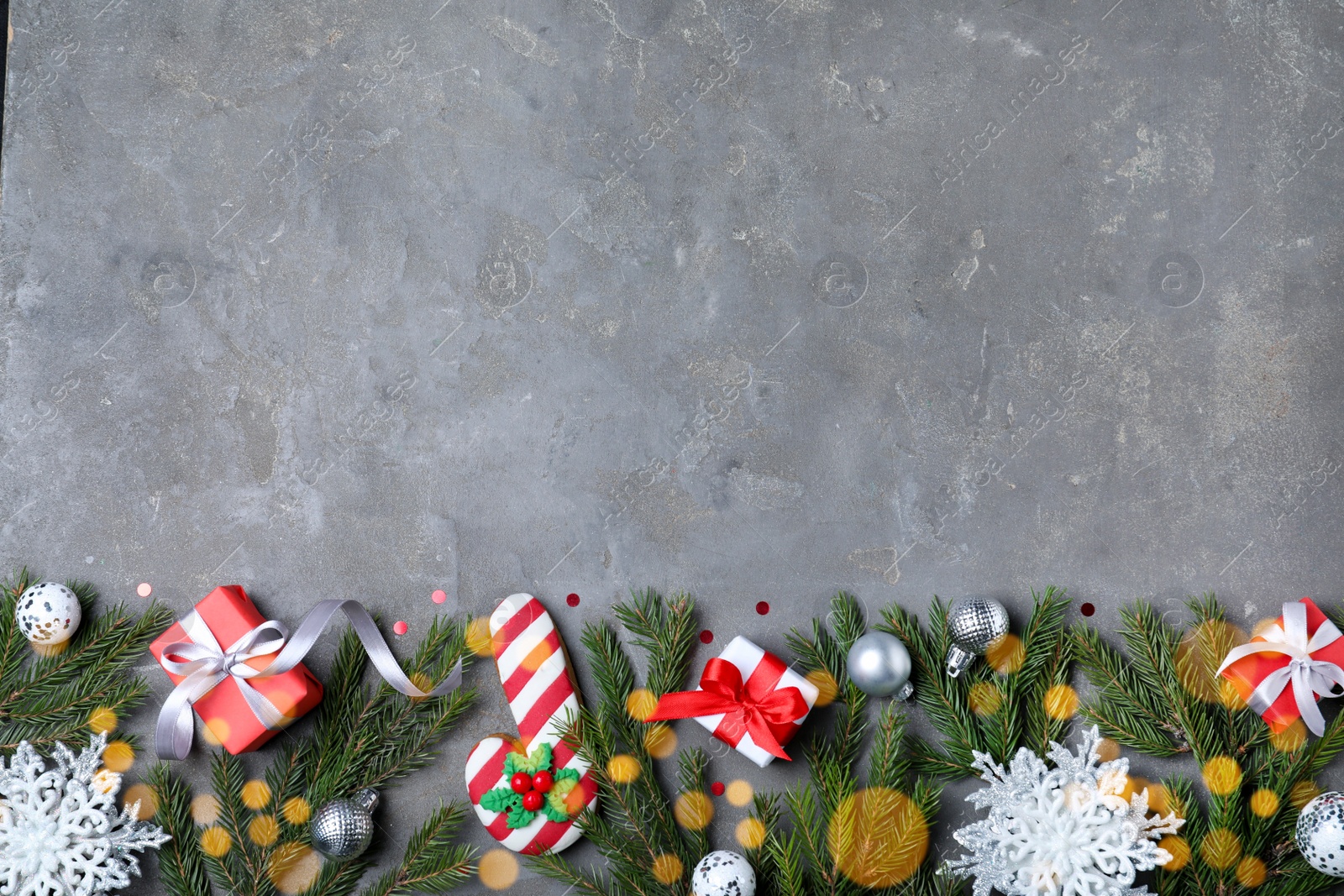 Photo of Flat lay composition with fir branches and Christmas decor on grey background, space for text. Greeting card design