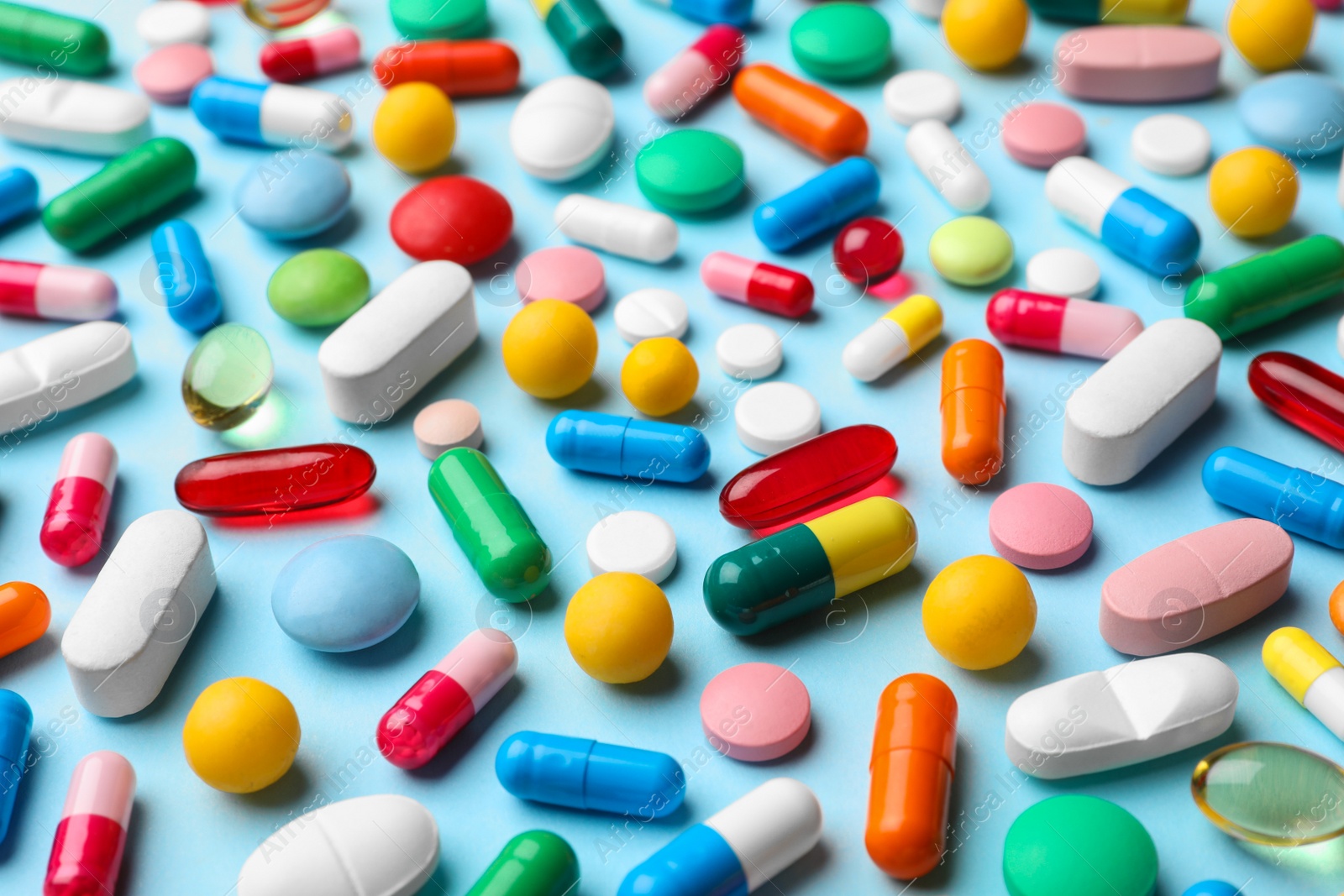 Photo of Different pills on color background, closeup view
