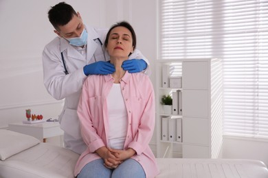 Photo of Doctor examining thyroid gland of patient in hospital, space for text