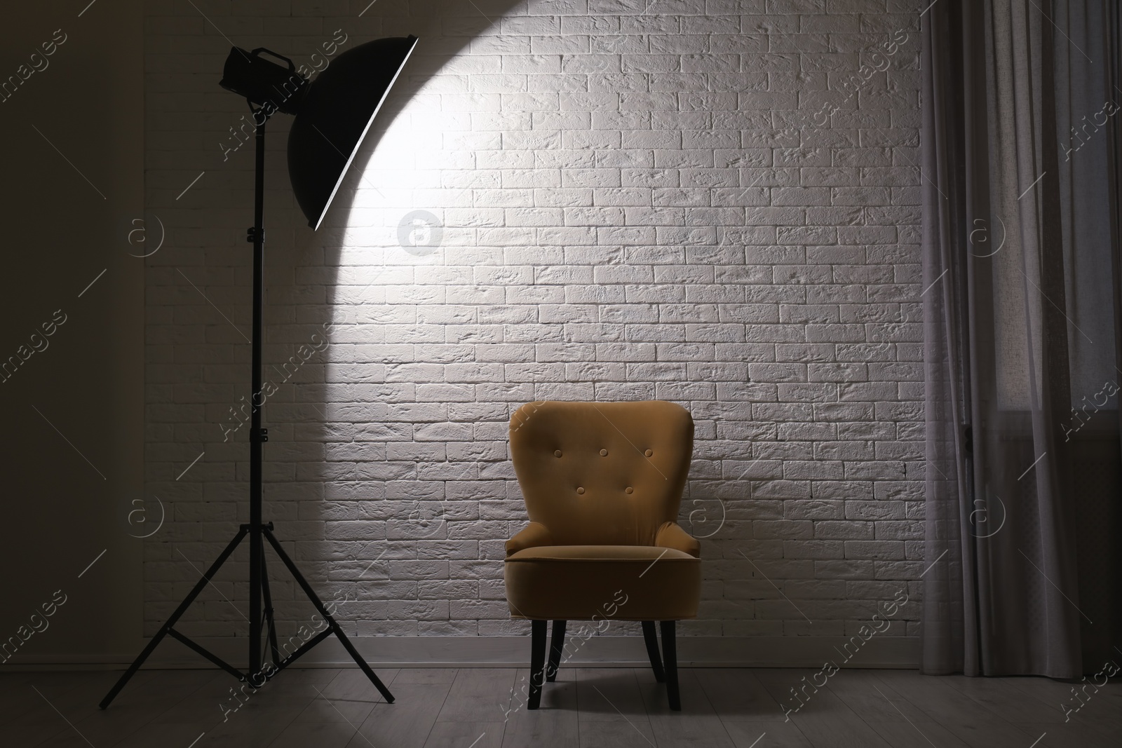 Photo of Interior of modern photo studio with professional lighting equipment and armchair