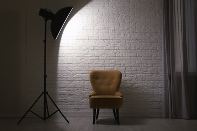 Interior of modern photo studio with professional lighting equipment and armchair