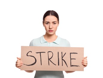 Upset young woman holding cardboard banner with word Strike on white background