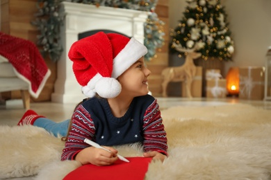 Photo of Cute child writing letter to Santa Claus at home. Christmas tradition