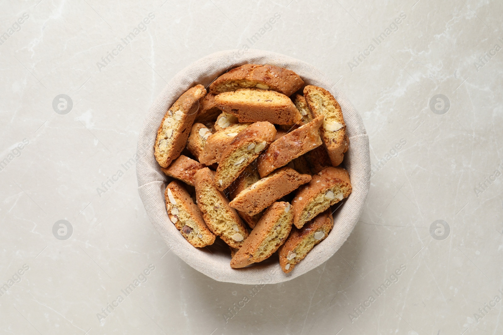 Photo of Traditional Italian almond biscuits (Cantucci) on light marble table, top view