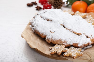 Photo of Traditional Christmas Stollen with icing sugar on white wooden table