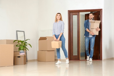Couple walking into their new house with moving boxes