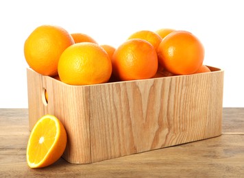 Fresh oranges in crate on wooden table against white background