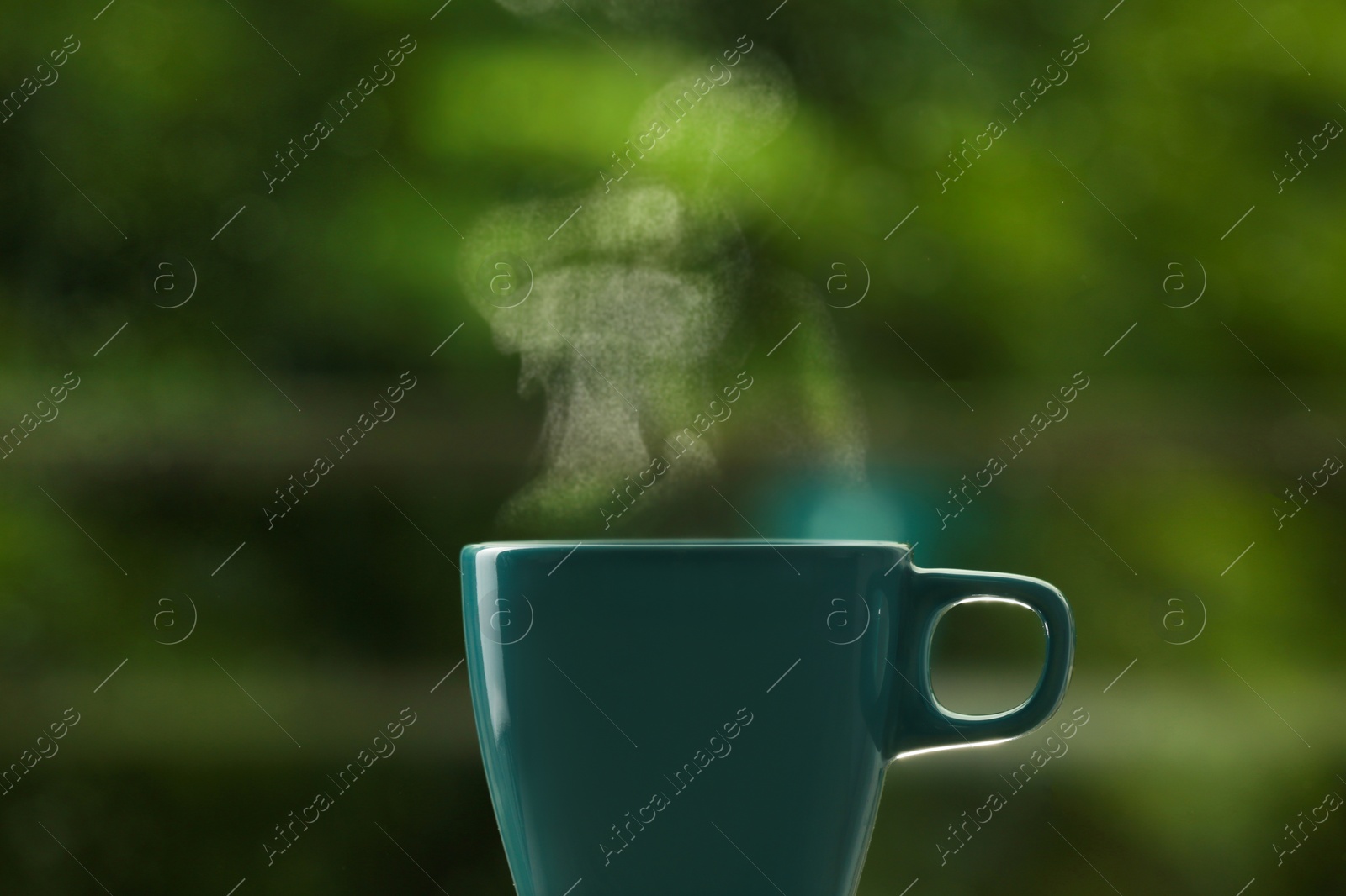 Photo of Cup of hot drink against blurred background, space for text