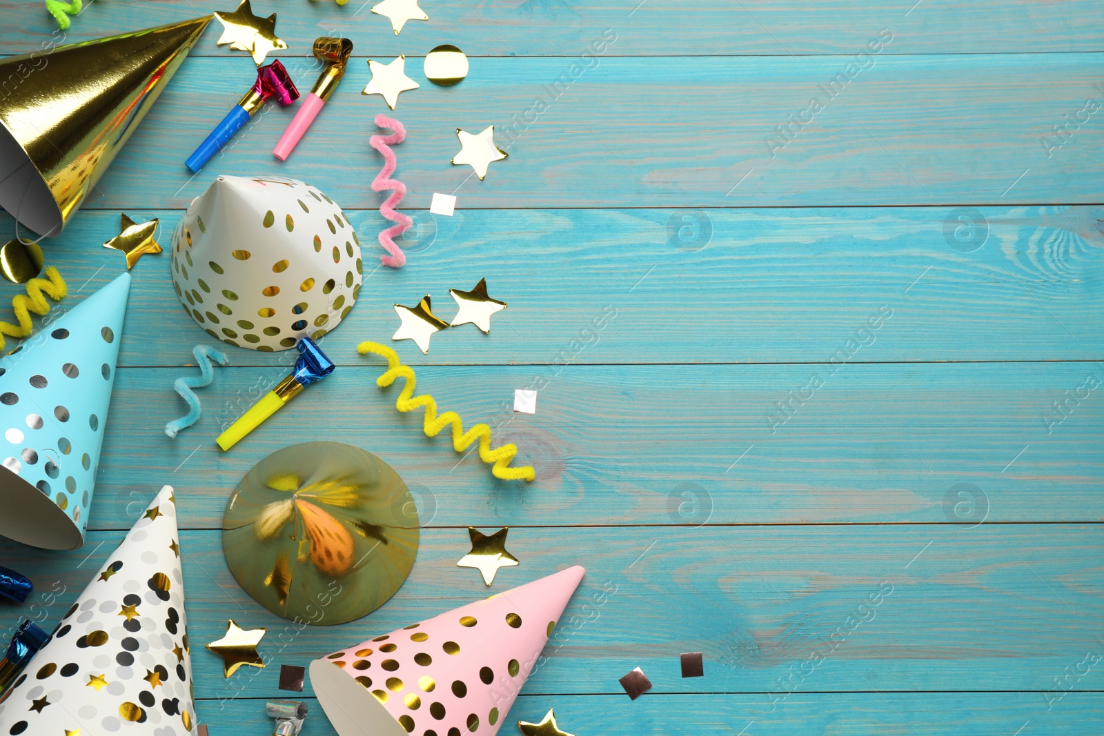 Photo of Flat lay composition with party hats and other festive items on light blue wooden background. Space for text