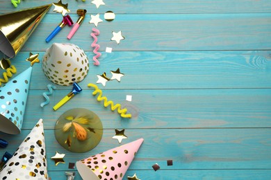 Photo of Flat lay composition with party hats and other festive items on light blue wooden background. Space for text