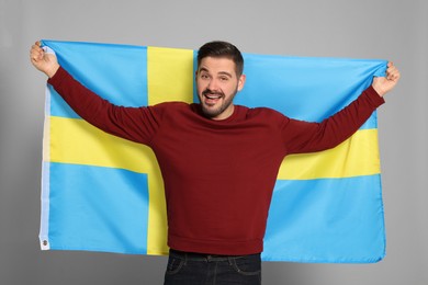 Photo of Man with flag of Sweden on light grey background