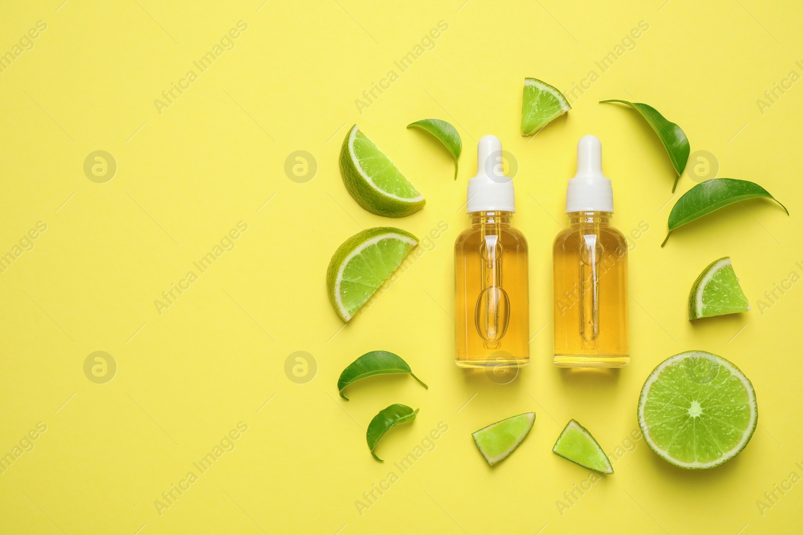 Photo of Flat lay composition with lime essential oil on yellow background. Space for text