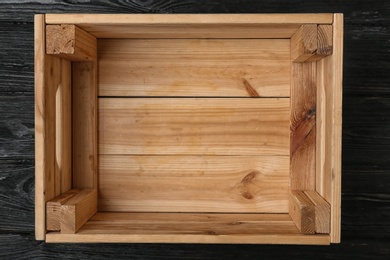 Photo of Empty wooden crate on dark background, top view