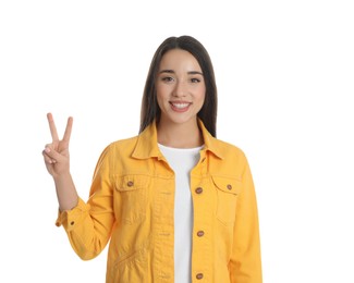 Woman in yellow jacket showing number two with her hand on white background