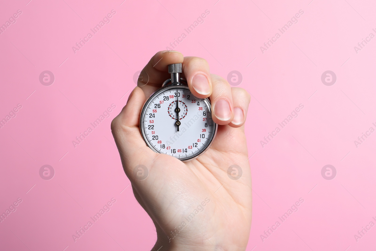 Photo of Woman holding vintage timer on pink background, closeup